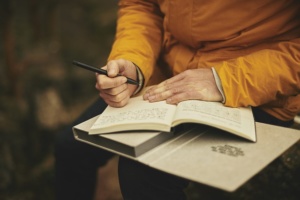 Person schreibt in einem Buch